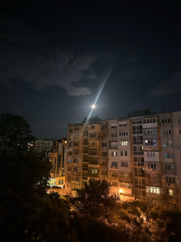Full moon rises over a quiet urban neighborhood at night