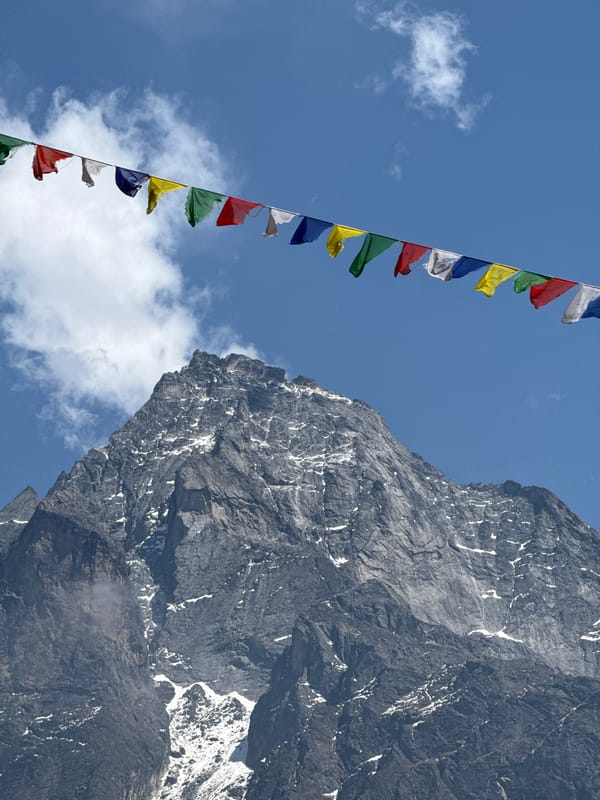 Prayer flags photographed against mountain backdrop in Khumjung, Nepal