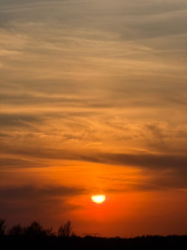Sunset observed with orange hues and cloud cover
