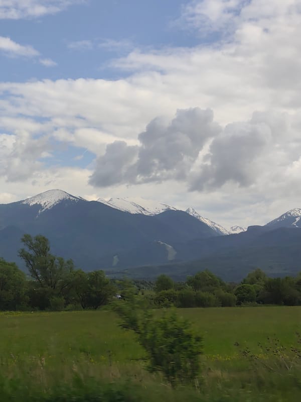Snow-capped Pirin Mountains viewed from Razlog field under overcast skies