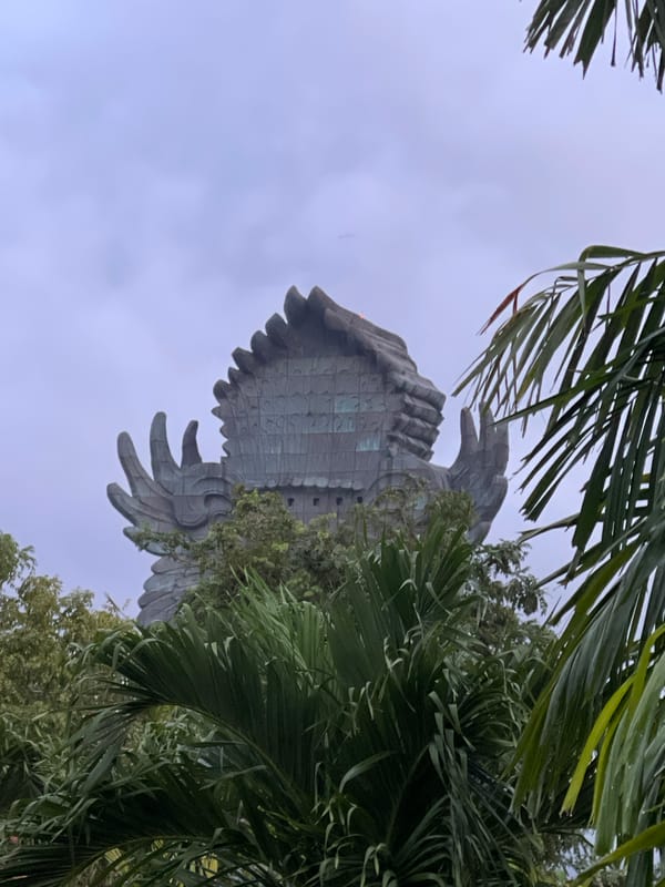 Monumental bird-like statue observed under overcast sky