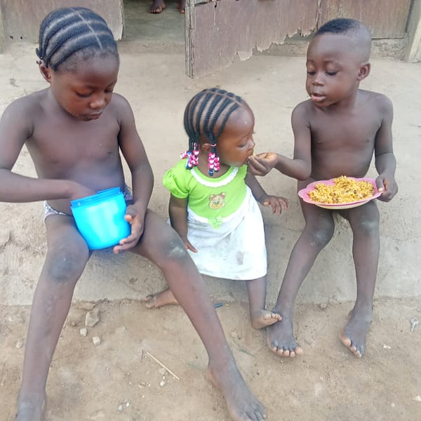 Young children share morning meal outdoors in Akwanga, Nigeria