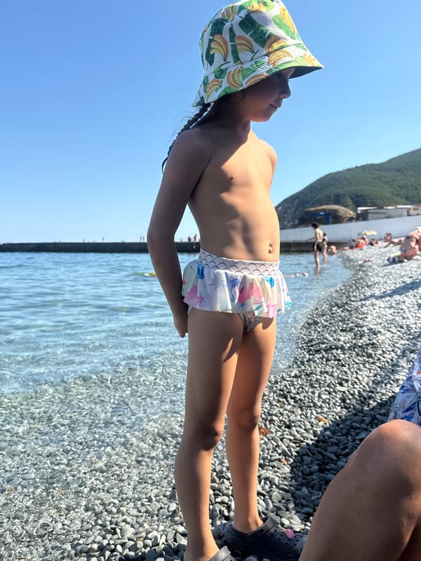Summer day at Partenit's pebble beach and sea pier
