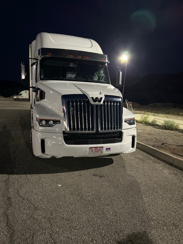Late-night roadside wrench work on a parked semi in Salina
