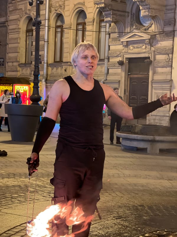 Street performers and vendors active during evening hours in Saint Petersburg