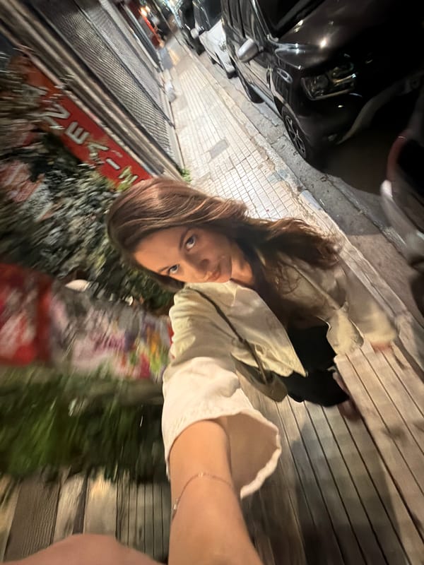 Woman takes selfies on Athens street at night