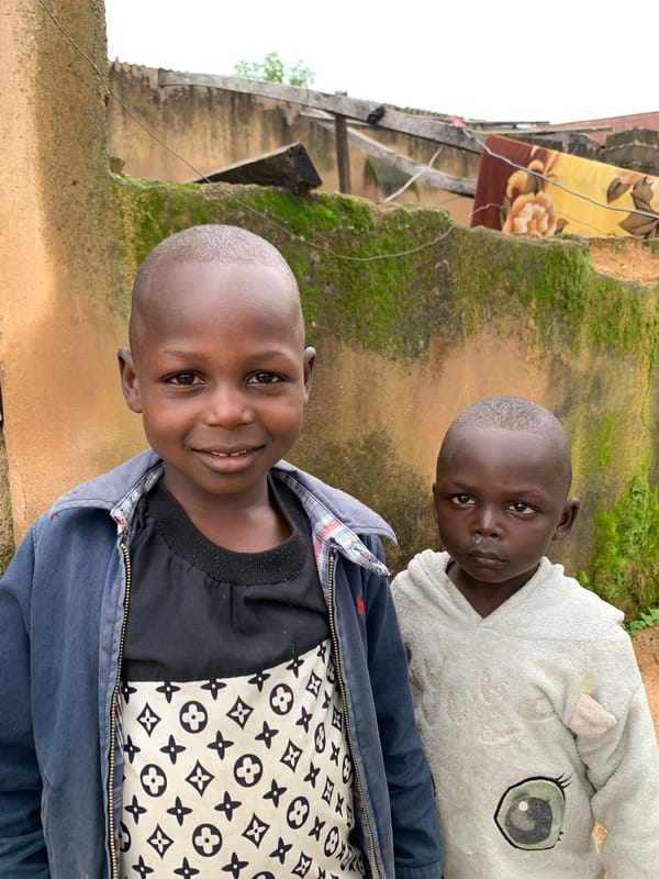 Kids outside a mossy ochre wall in Jos, Nigeria