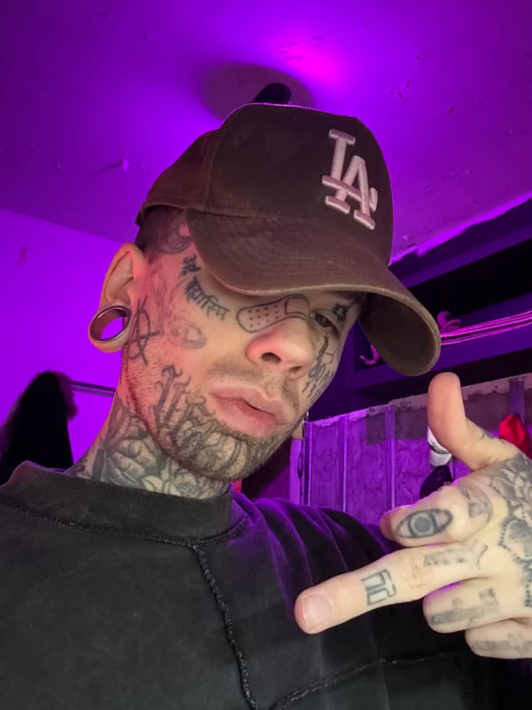 Tattooed face, purple light, LA cap — Buenos Aires selfie