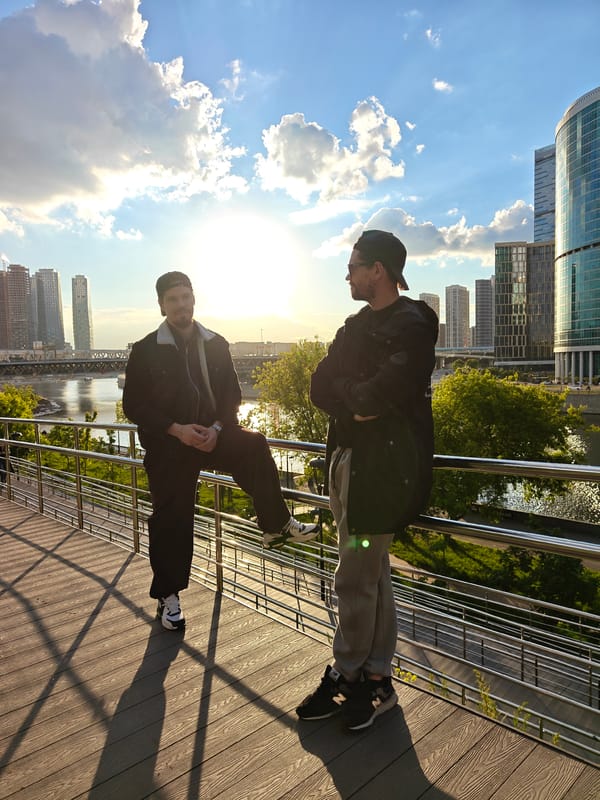 Two men converse on Moscow pedestrian bridge near business district