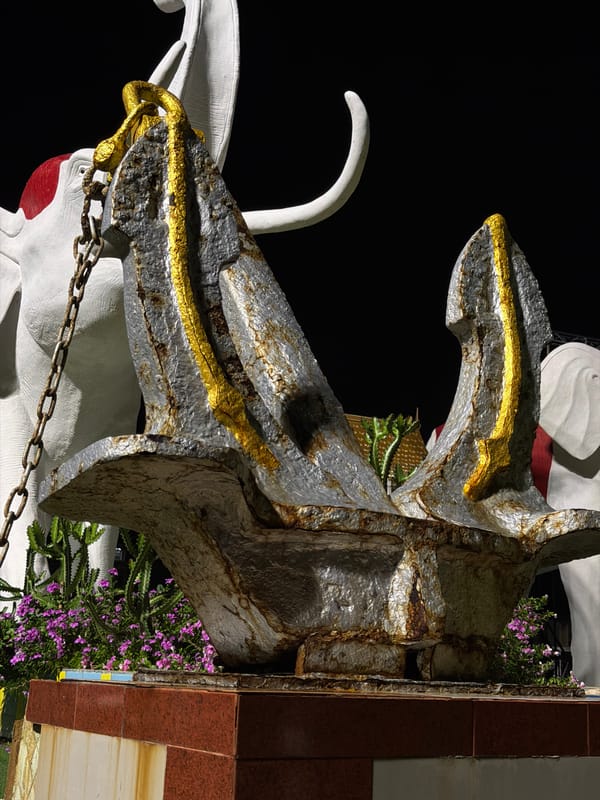 Rainy night at Pattaya's waterfront: waves, sculptures, and boats
