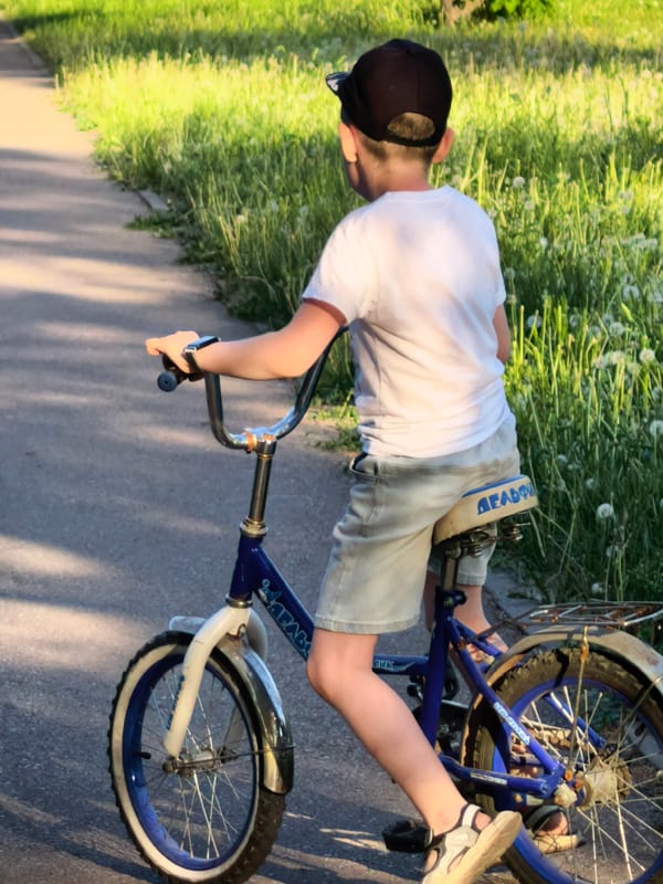 Boy rides bicycle through park in Sterlitamak, Russia