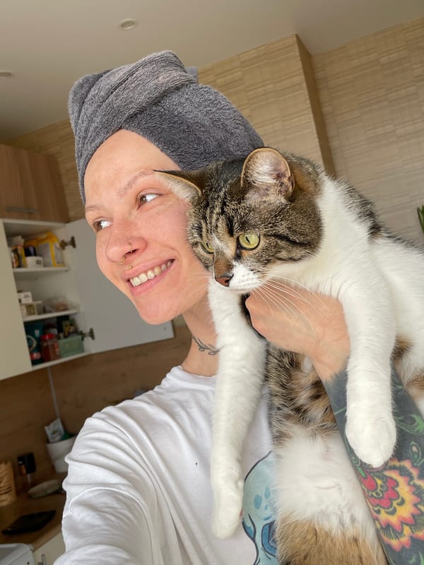 Person holds tabby cat while wearing towel in Izhevsk