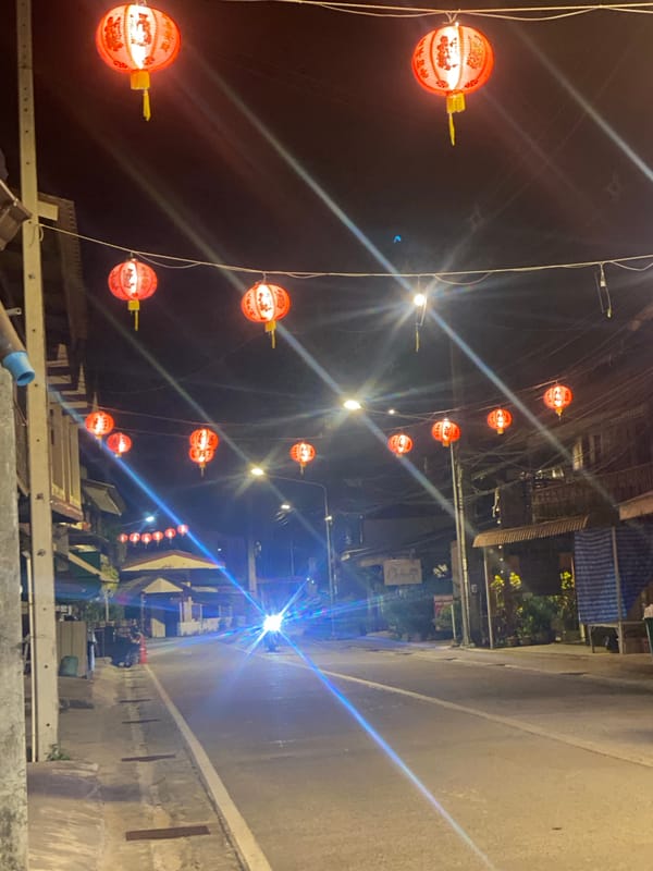 Nighttime street lights illuminate Baan Tai Thailand commercial district