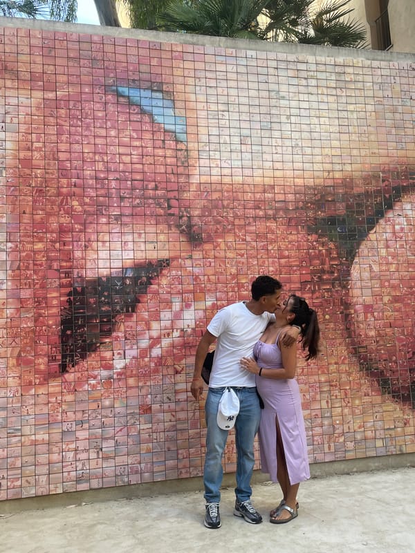 Tourists pose at Barcelona's famous Kiss of Freedom mural