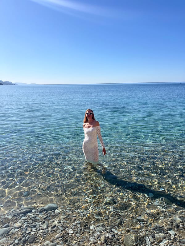 Woman enjoys morning beach moment in clear waters near Budva