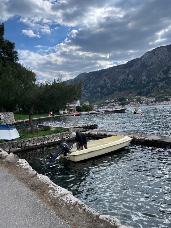 Man tends boat at Montenegro waterfront in Dobrota