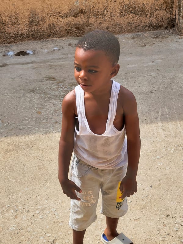 Child plays with soccer ball outside Suleja building