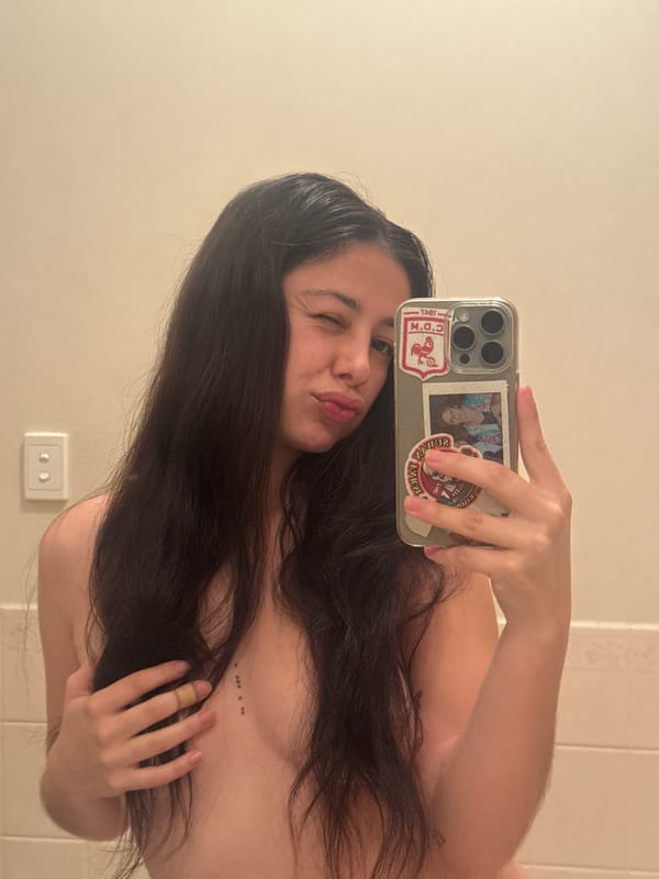 Woman takes mirror selfies in tiled room in Como