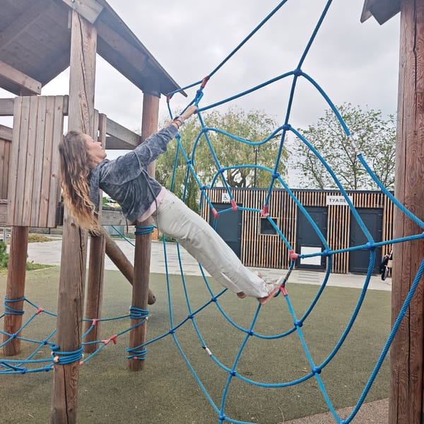 Woman climbs playground rope structure in Shcholkino, Ukraine