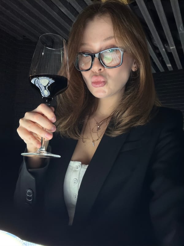 Woman poses playfully with wine glass in tilted portrait