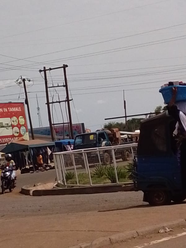 Street scene captured in Tamale with tricycle, basket carrier