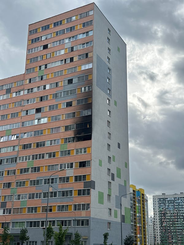 Murino street life alongside fire-damaged residential buildings