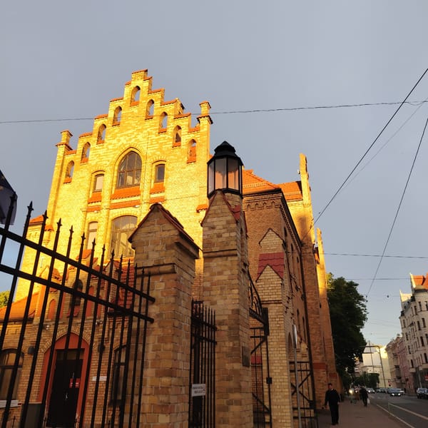 Anonymous witness photographs Riga's historic architecture during evening walk