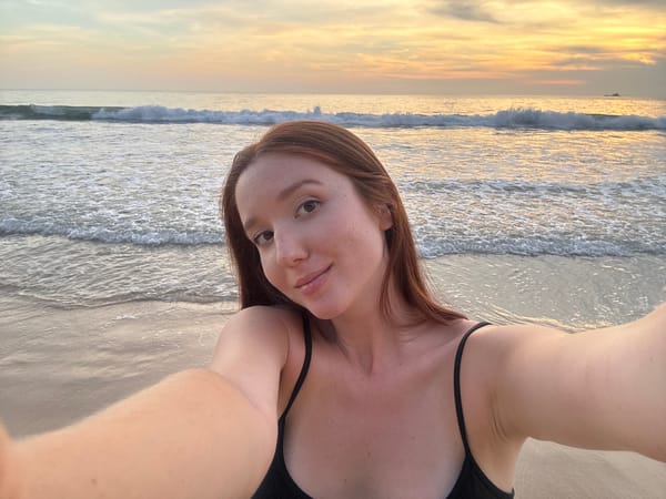 Woman captures sunset selfie on Bang Tao Beach, Thailand