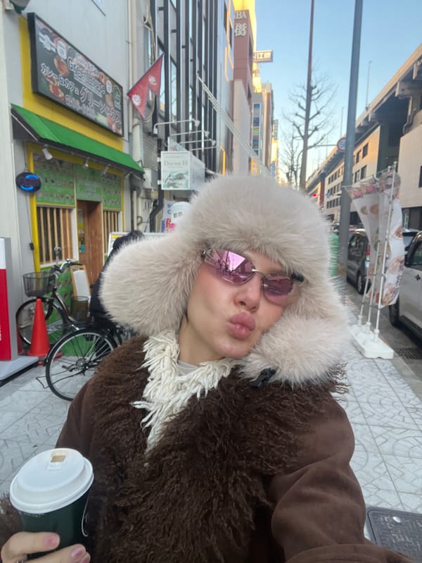Woman in pink sunglasses, fur hat documented across Osaka