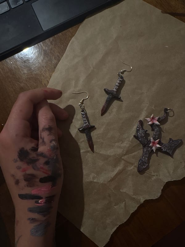 Person arranges dark jewelry pieces on paper in Yerevan