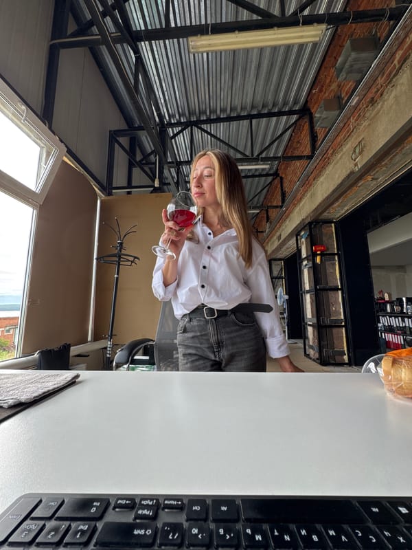 Woman with wine glass observed in industrial office space