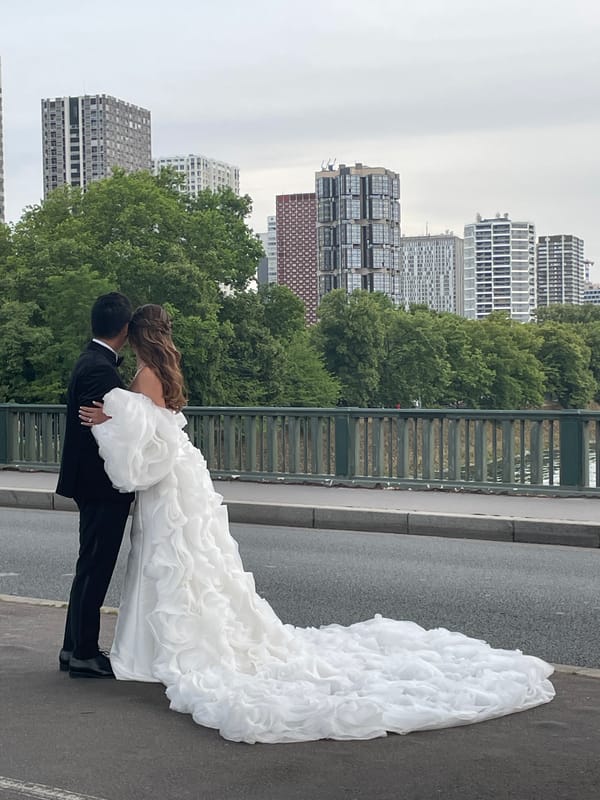 Wedding couple poses on Paris bridge with Eiffel Tower backdrop