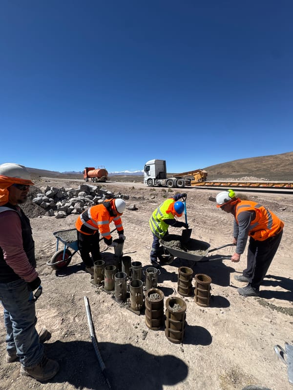 Construction crew fills concrete molds on roadside in Putre, Chile