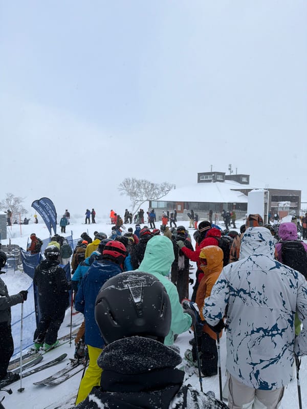 Skiers gather in line during snowy day in Kutchan
