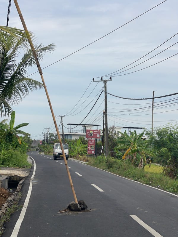 Bamboo pole blocks street through pothole in Kediri, Indonesia