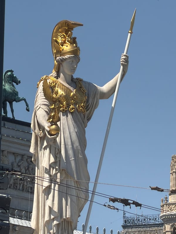 Vienna's Parliament and its classical statuary on a sunny morning