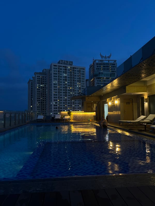 Woman relaxes poolside with phone in Nha Trang