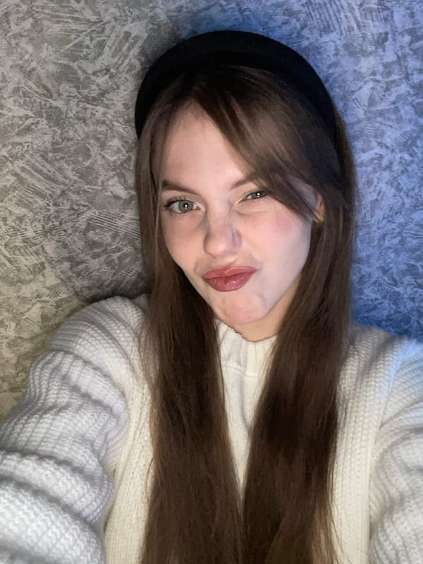 Woman in white sweater rests indoors in Foki, Russia
