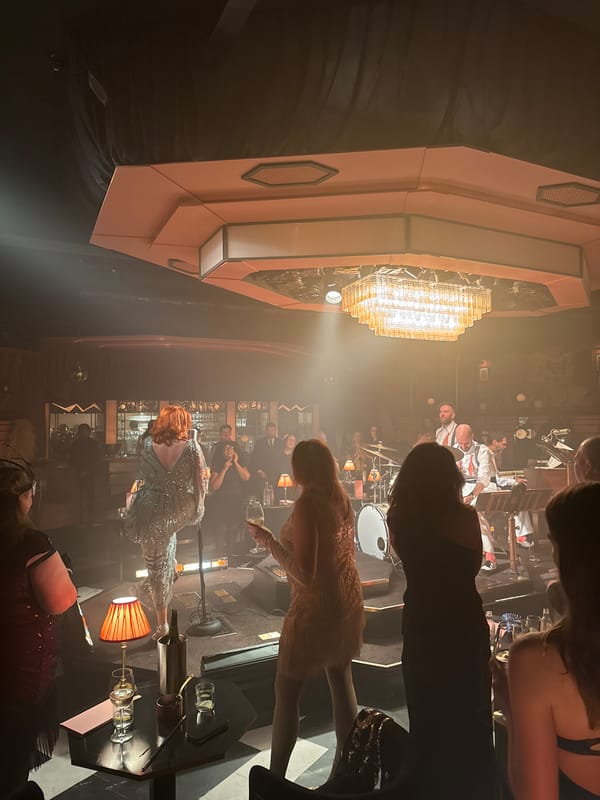 Art deco venue with patrons, performers captured in dim lighting