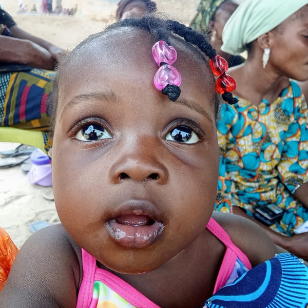 Women and children gather informally on mats in Doma, Nigeria