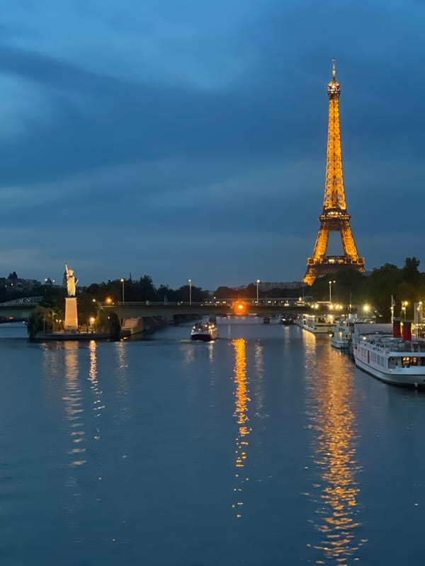 Eiffel Tower glowing gold over the Seine at dusk