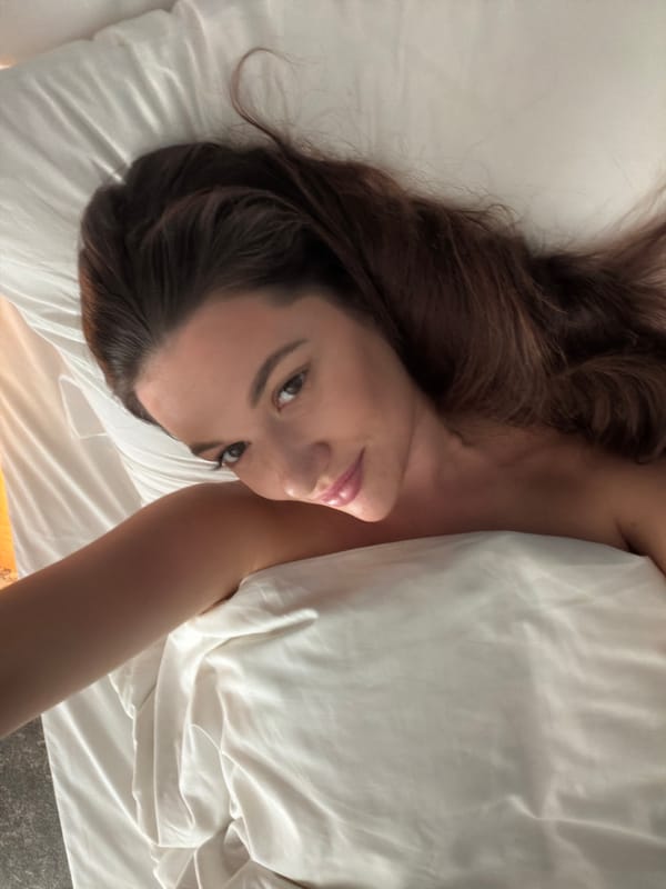 Woman photographed on bed in Athens morning scene