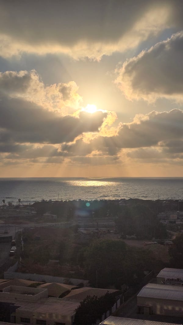 Sun breaking through clouds over Bat Yam's skyline
