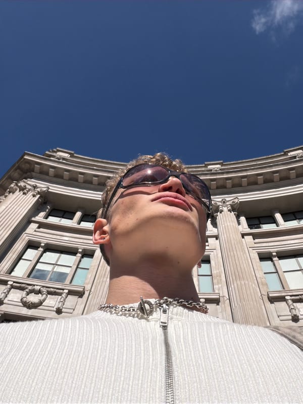 Person in sunglasses and white jacket photographed in London