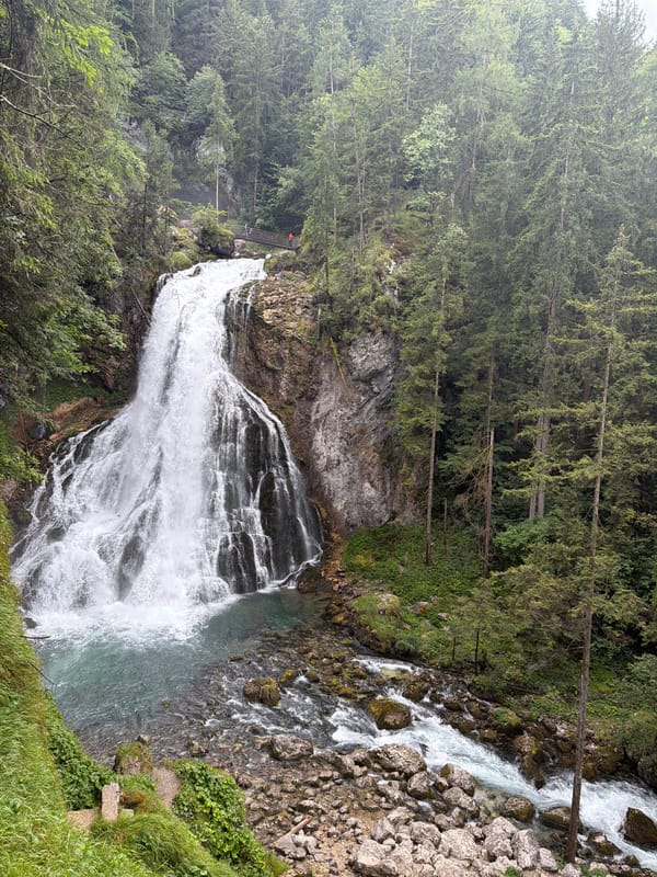 Powerful waterfall cascades through forested alpine cliffs in Kellau