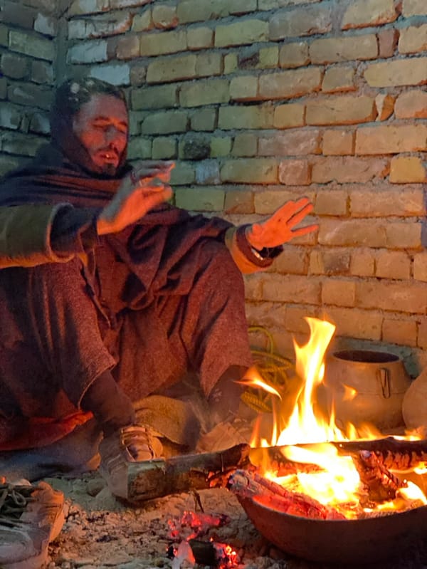 Men gather around campfires for warmth in Kandahar