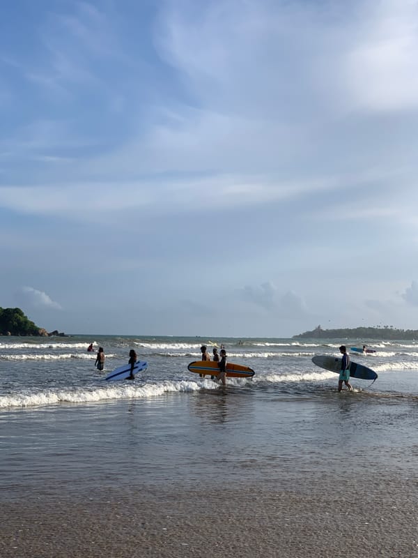 Busy morning surf session and beach activities in Weligama