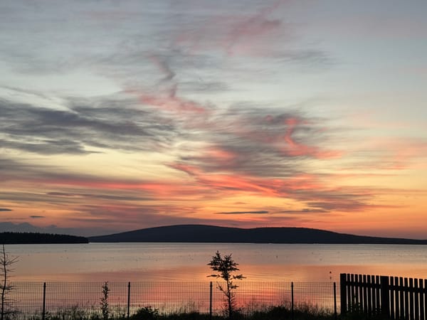 Quiet lakeside sunset from a patio bench