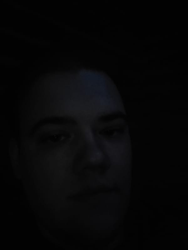 Person in dark room with computer monitor and lighting