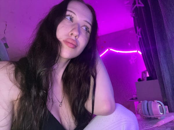 Woman Takes Extended Selfie Session in Purple-Lit Votkinsk Bedroom
